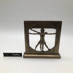 Figurka człowieka witruwiańskiego w geometrycznej ramie